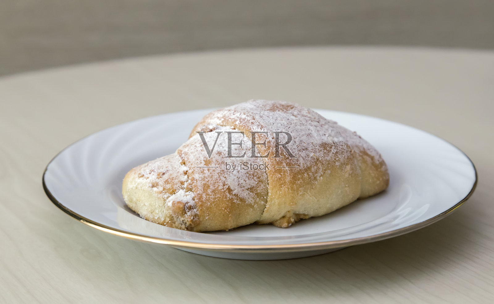 木桌上放着一杯咖啡和肉桂卷。照片摄影图片