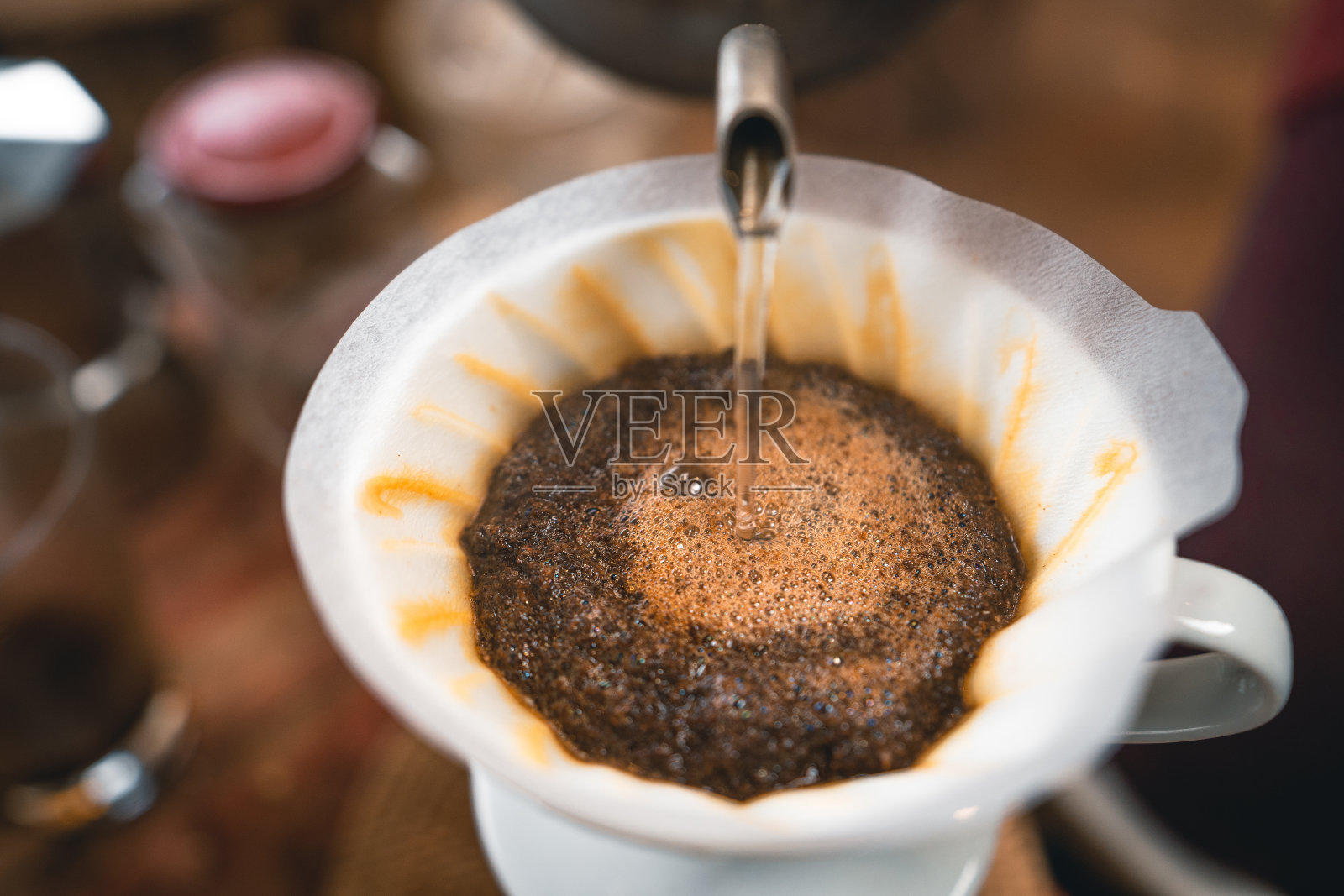 把咖啡热水从壶里滴进咖啡里。照片摄影图片