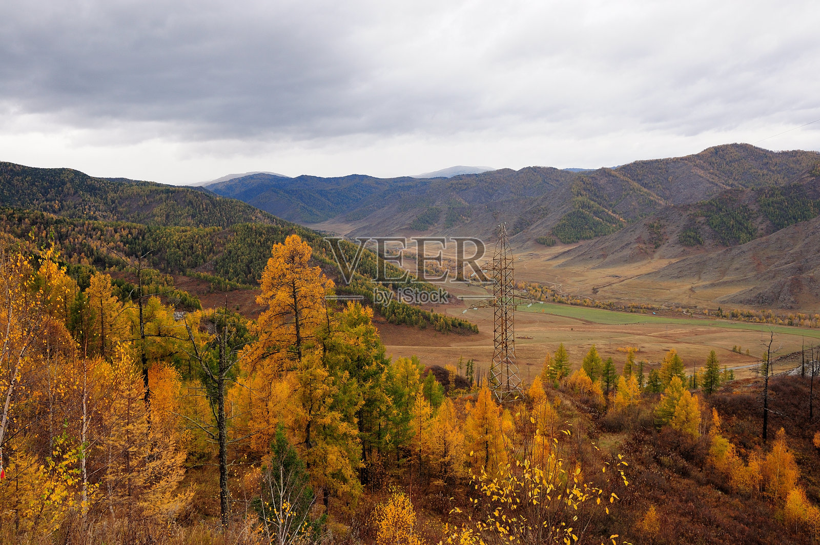 从山顶到一个风景如画的山谷覆盖着秋天的颜色在山间的空心和高功率线柱。照片摄影图片