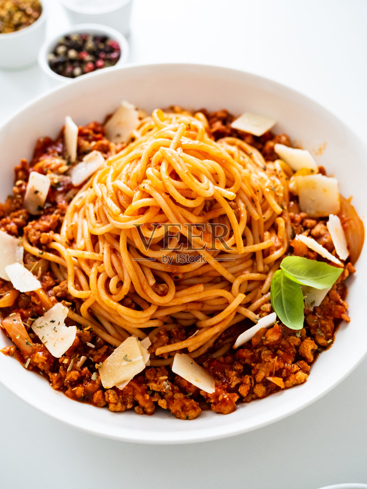 意大利肉酱面-白底上加肉末和番茄酱的意大利面照片摄影图片