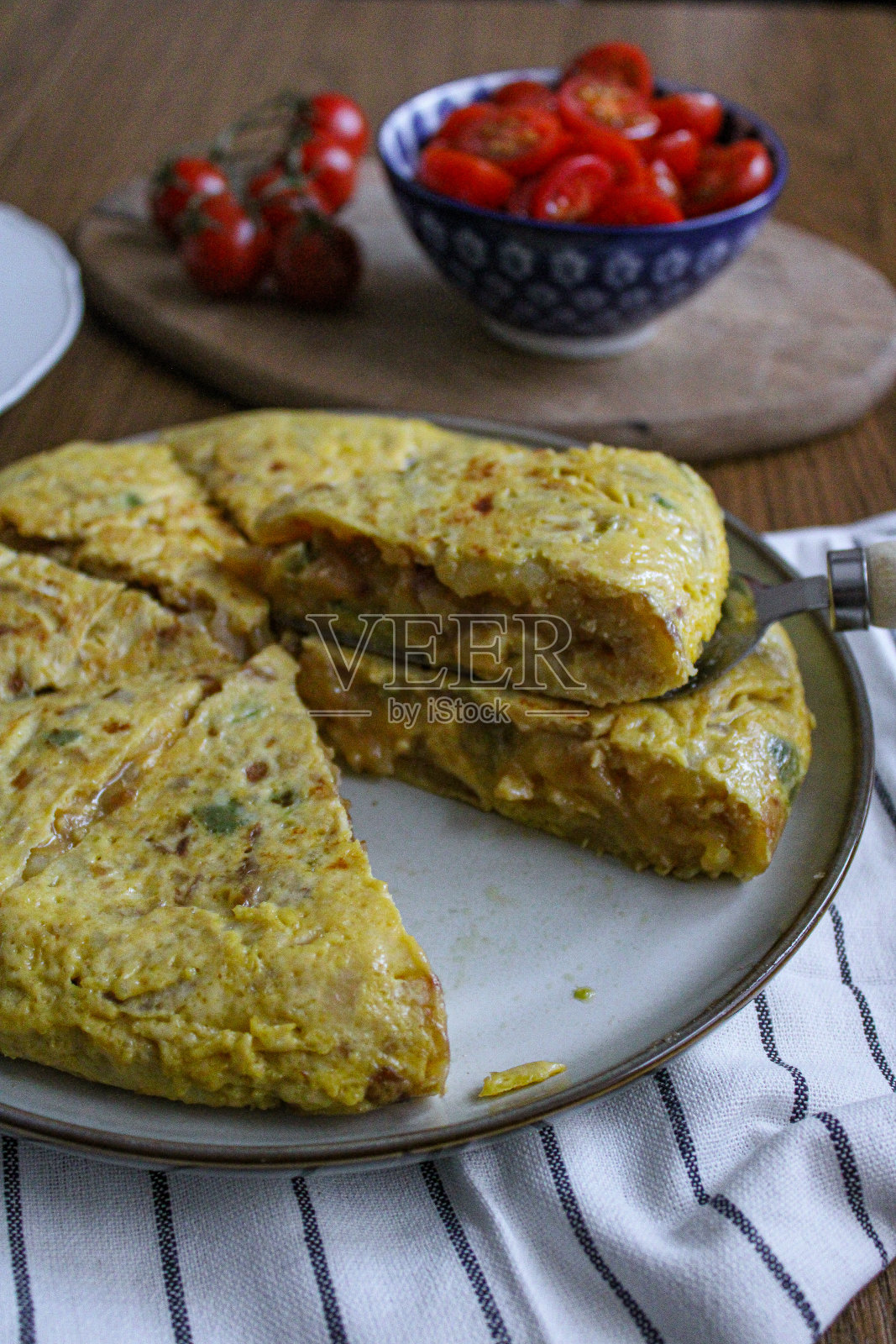 西班牙玉米饼土豆煎蛋卷俯视图。洋葱蛋和土豆做成的切片圆煎蛋卷。装盘和准备服务。照片摄影图片