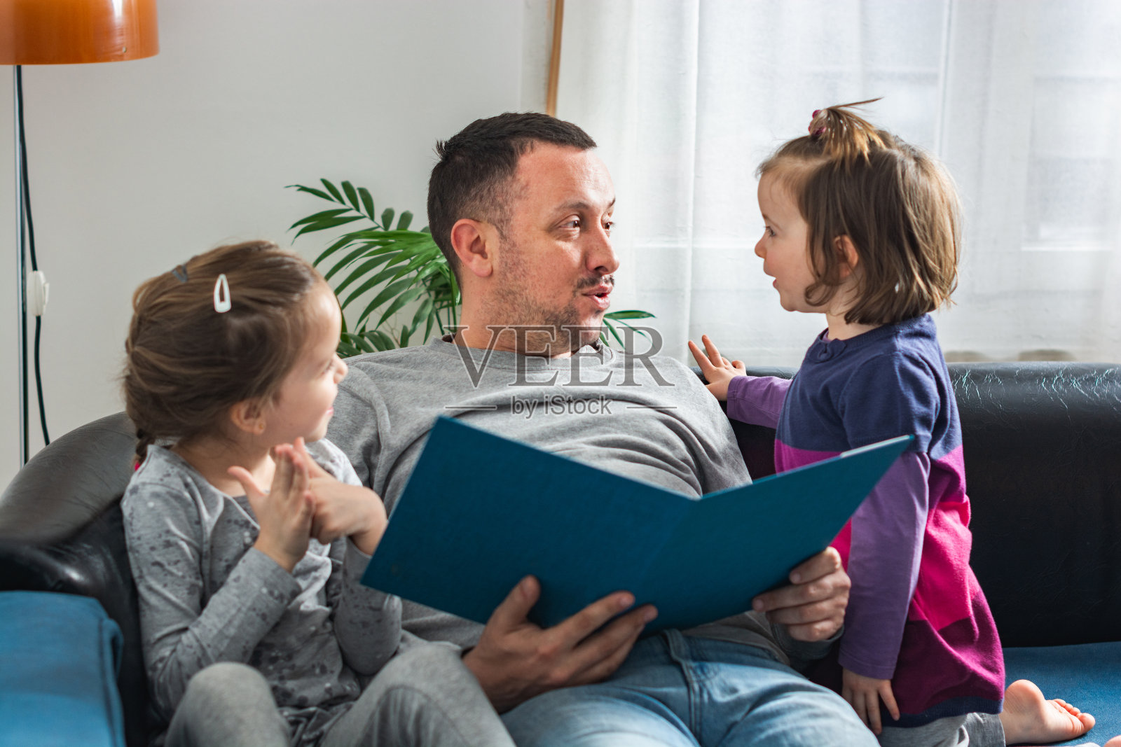一家人在客厅里微笑着看书照片摄影图片