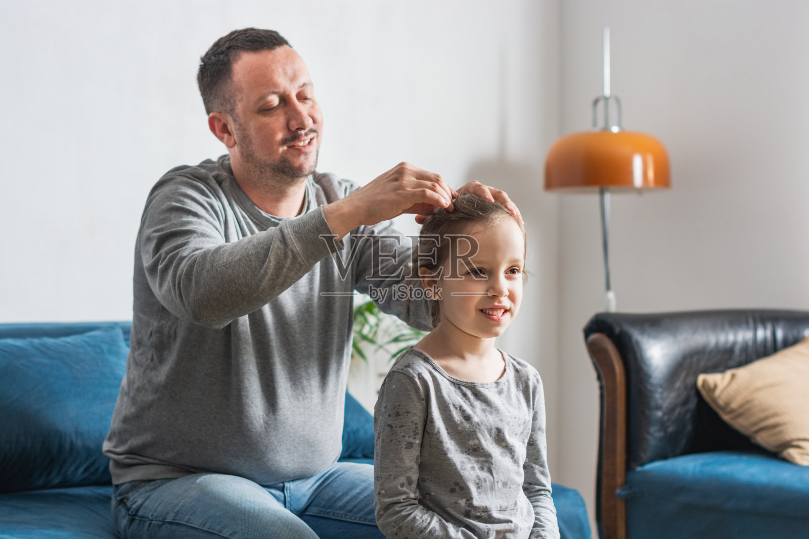 爸爸在家里给他的小女儿扎马尾辫照片摄影图片