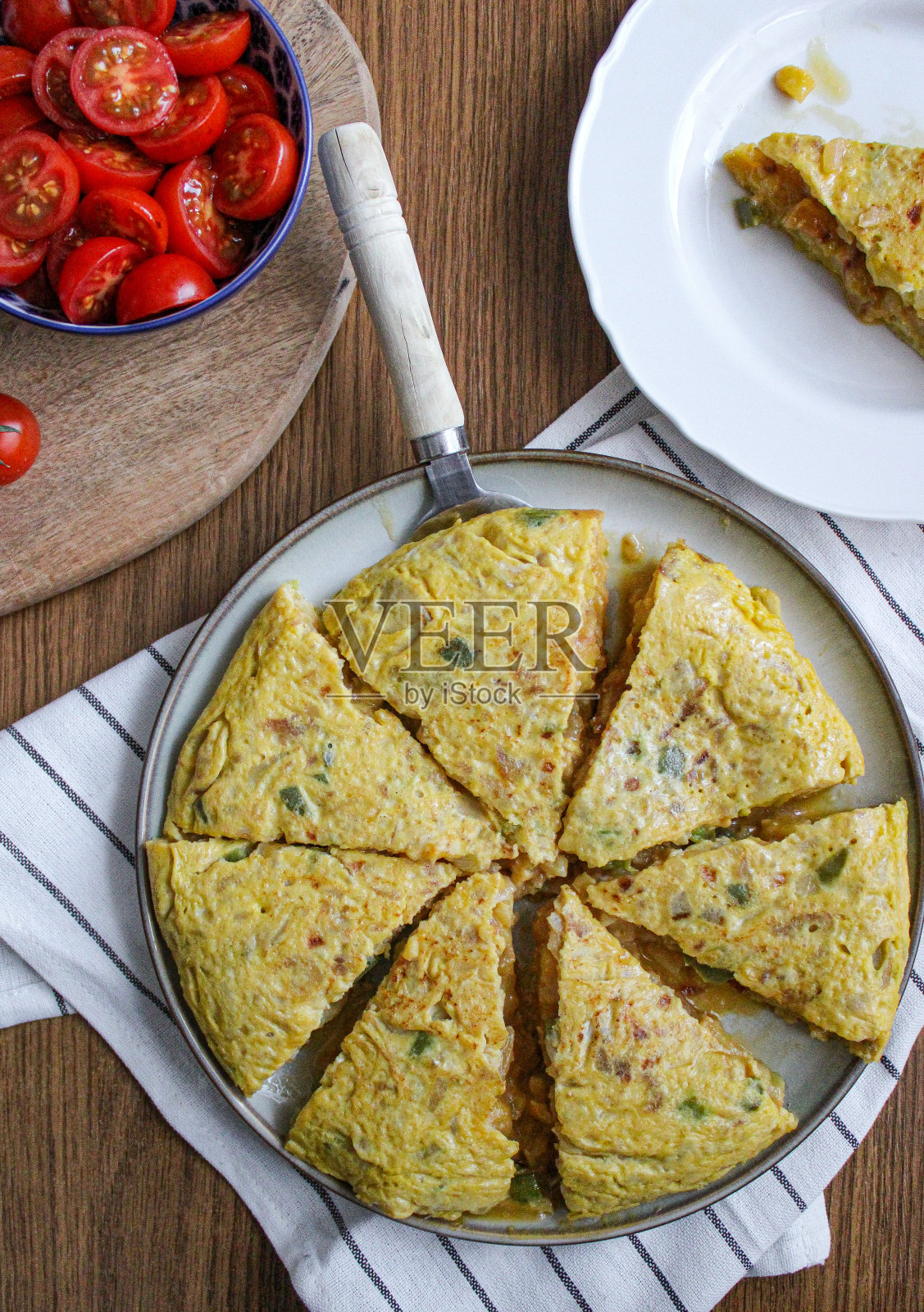 西班牙玉米饼土豆煎蛋卷俯视图。洋葱蛋和土豆做成的切片圆煎蛋卷。装盘和准备服务。照片摄影图片