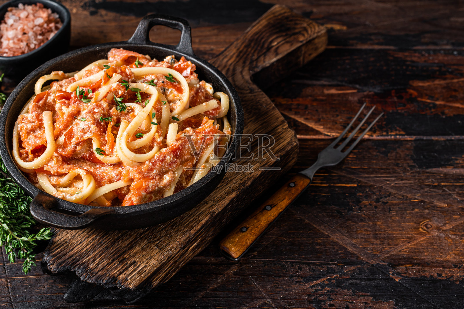 时尚的烤羊乳酪意面配烤番茄和芝士。深色木制背景。前视图。本空间照片摄影图片