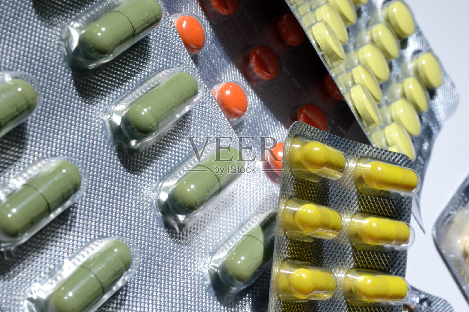 多色药片在箔泡躺在一个轻的背景。特写镜头。照片摄影图片