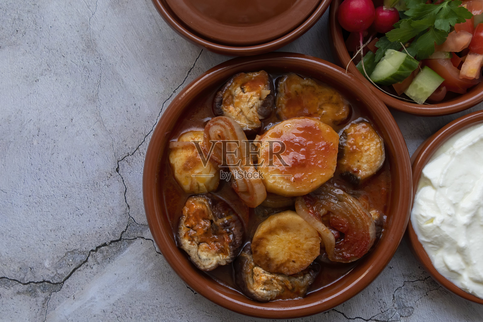 各种蔬菜在烤锅里煮，配酸奶和蔬菜沙拉。照片摄影图片