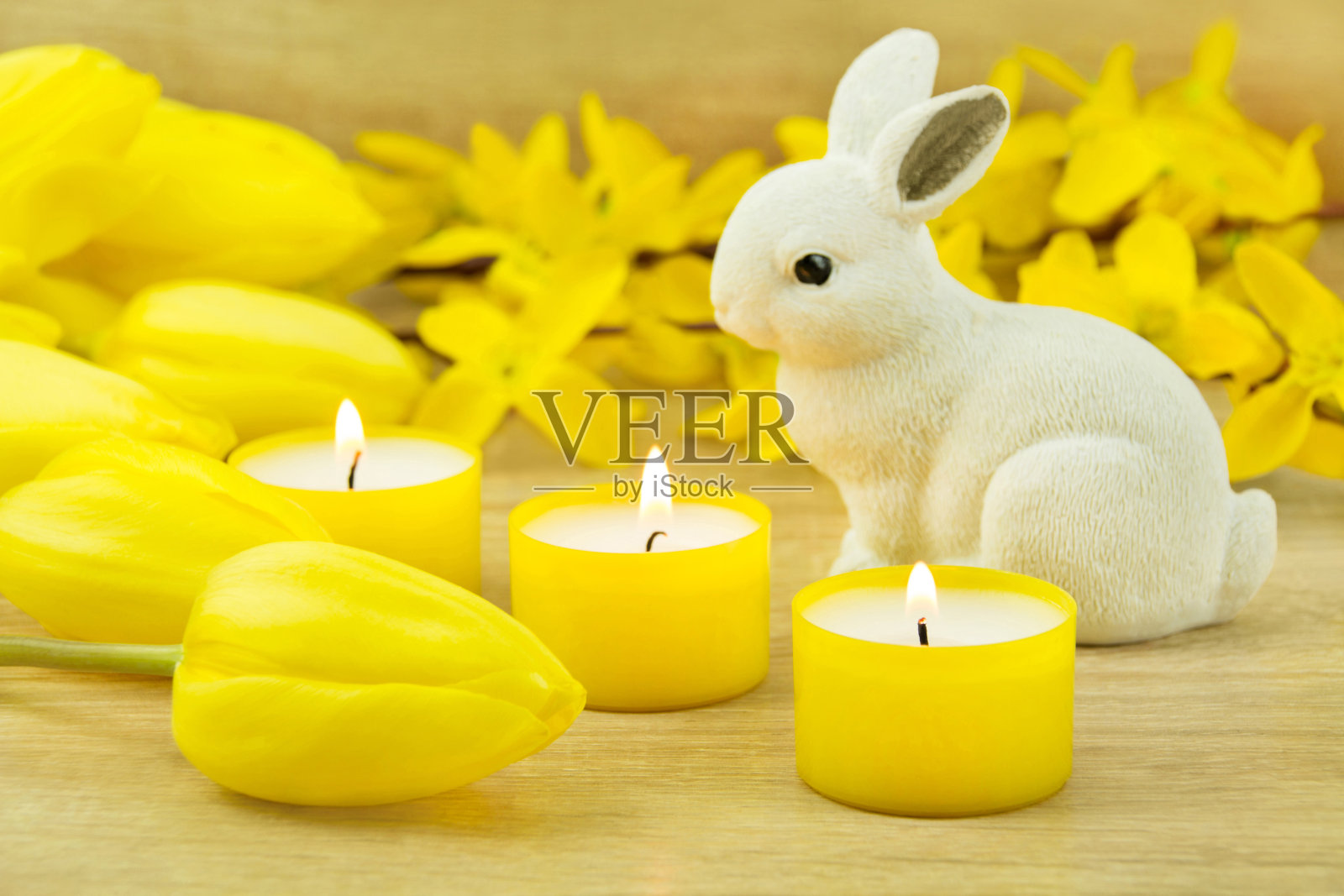 带着黄色郁金香和蜡烛的复活节兔子照片摄影图片