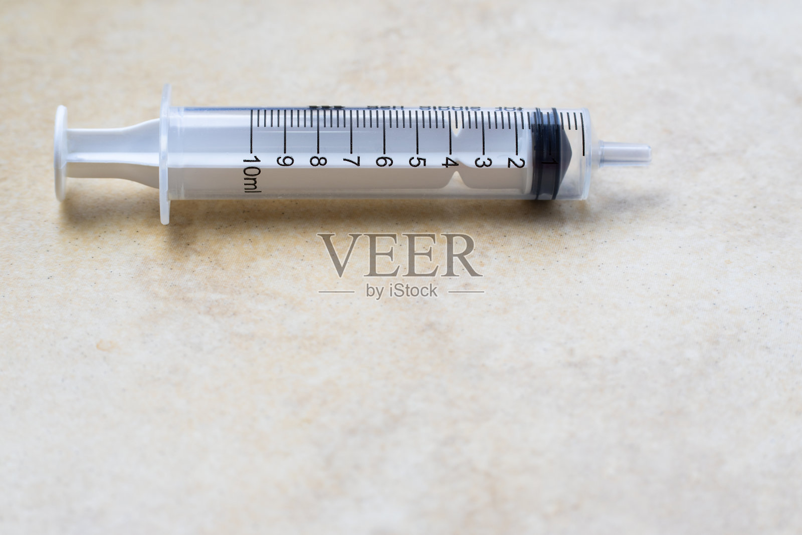 10ml无针药用注射器水平放置在透明底座上，下面有足够的复制空间照片摄影图片