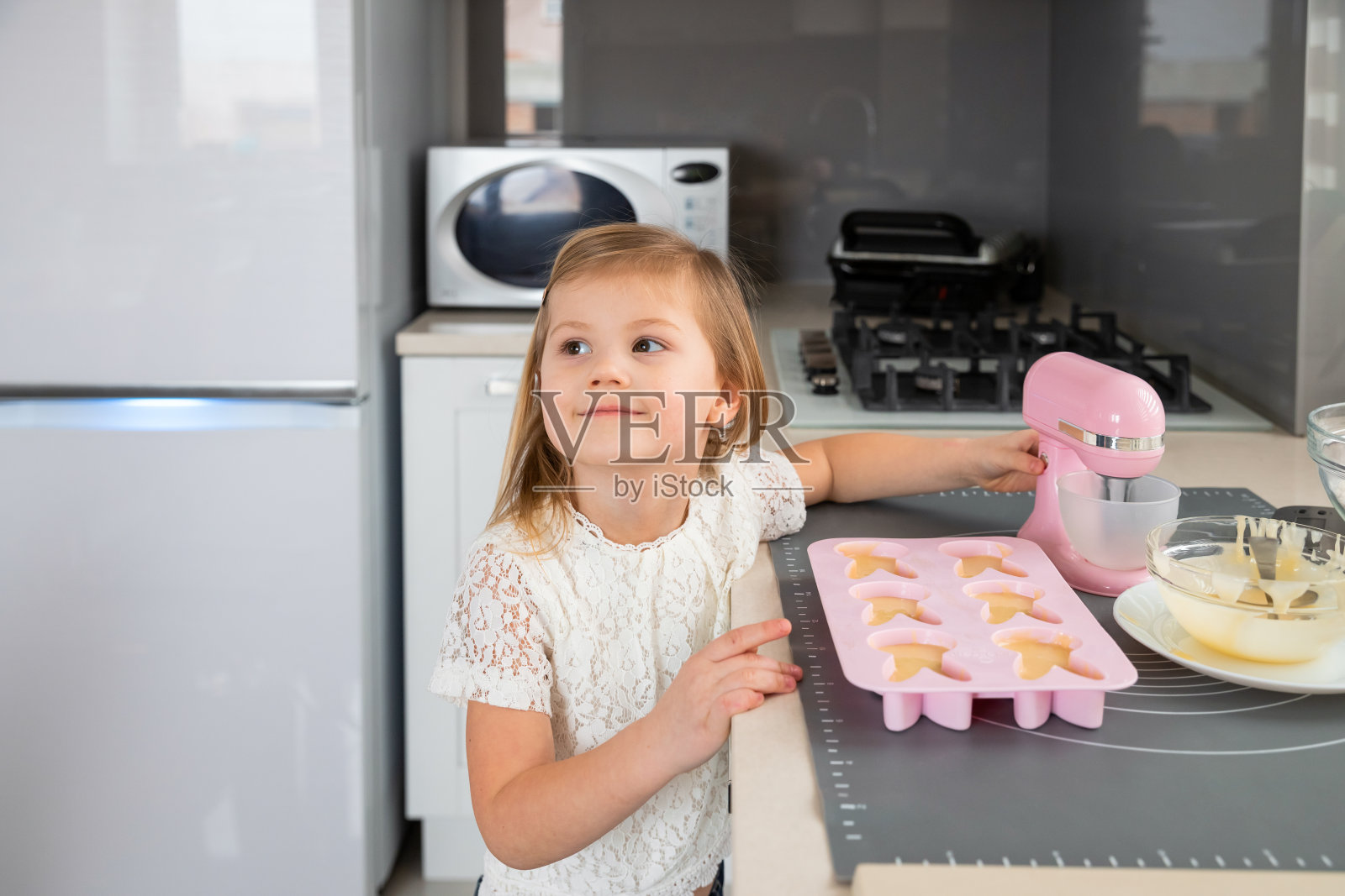 小女孩在厨房做纸杯蛋糕照片摄影图片