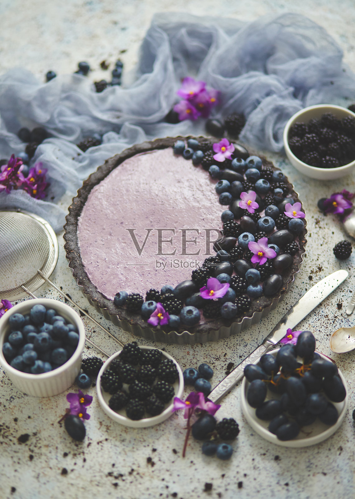 自制的黑莓馅饼。有黑莓、蓝莓和葡萄的甜派放在石头桌上照片摄影图片