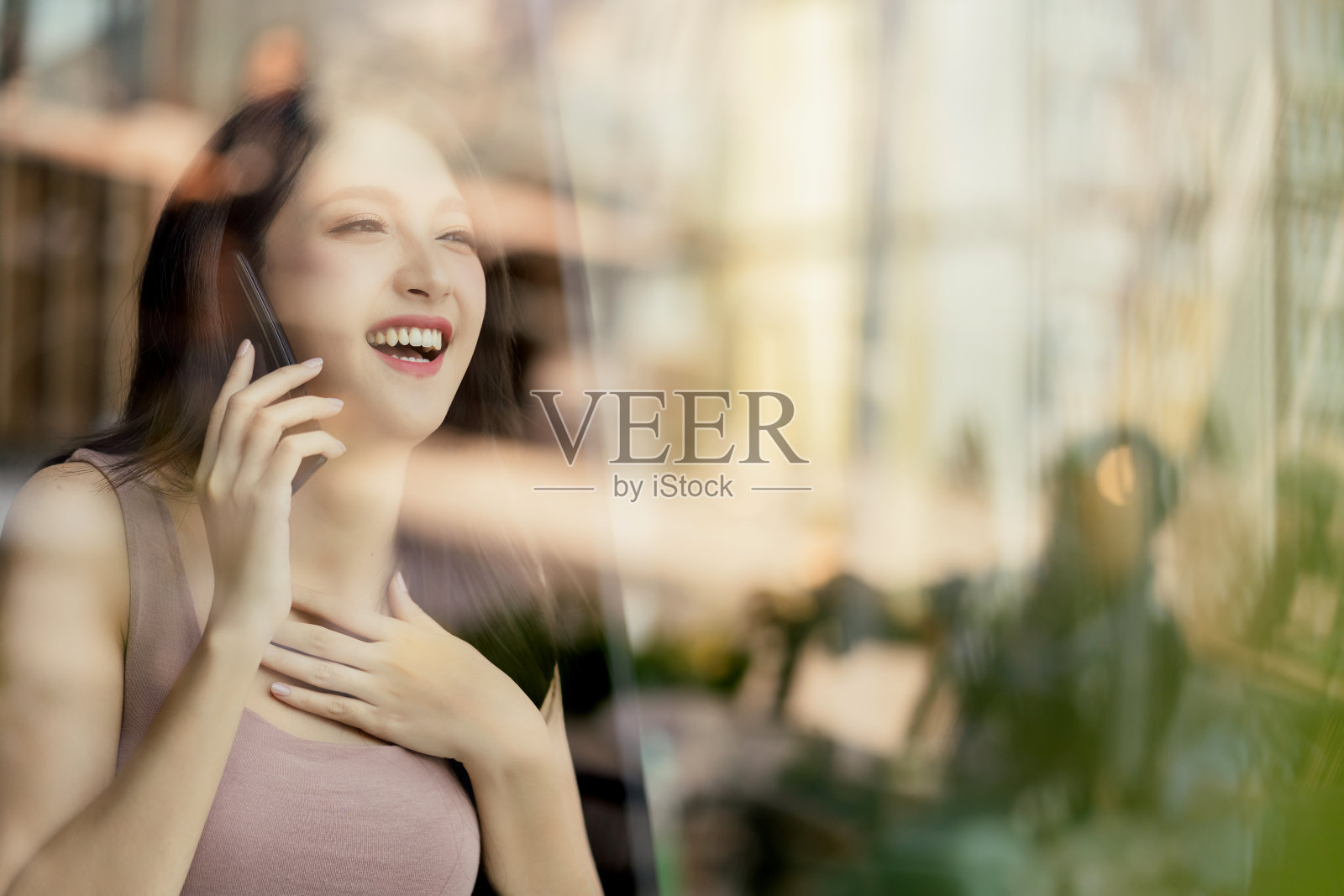 迷人的女性成年女性休闲服装幸福谈话惊喜情感表达手握智能手机交流与反映视野的户外商店照片摄影图片