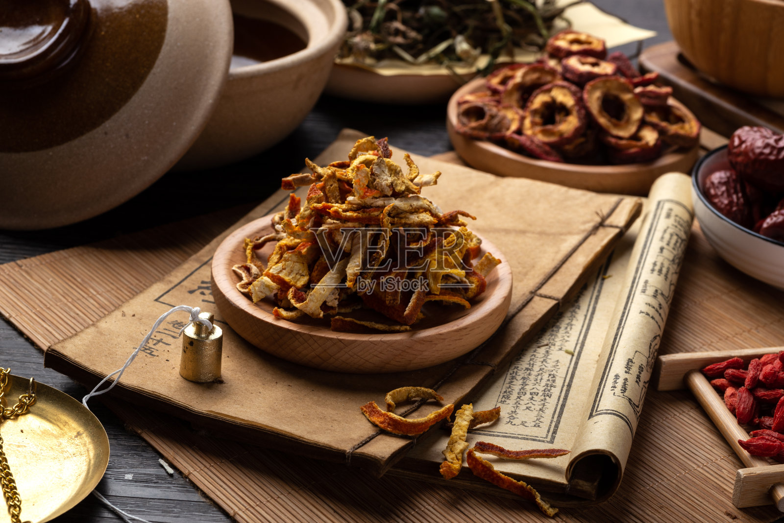 桌上放着古老的中医书籍和药草照片摄影图片