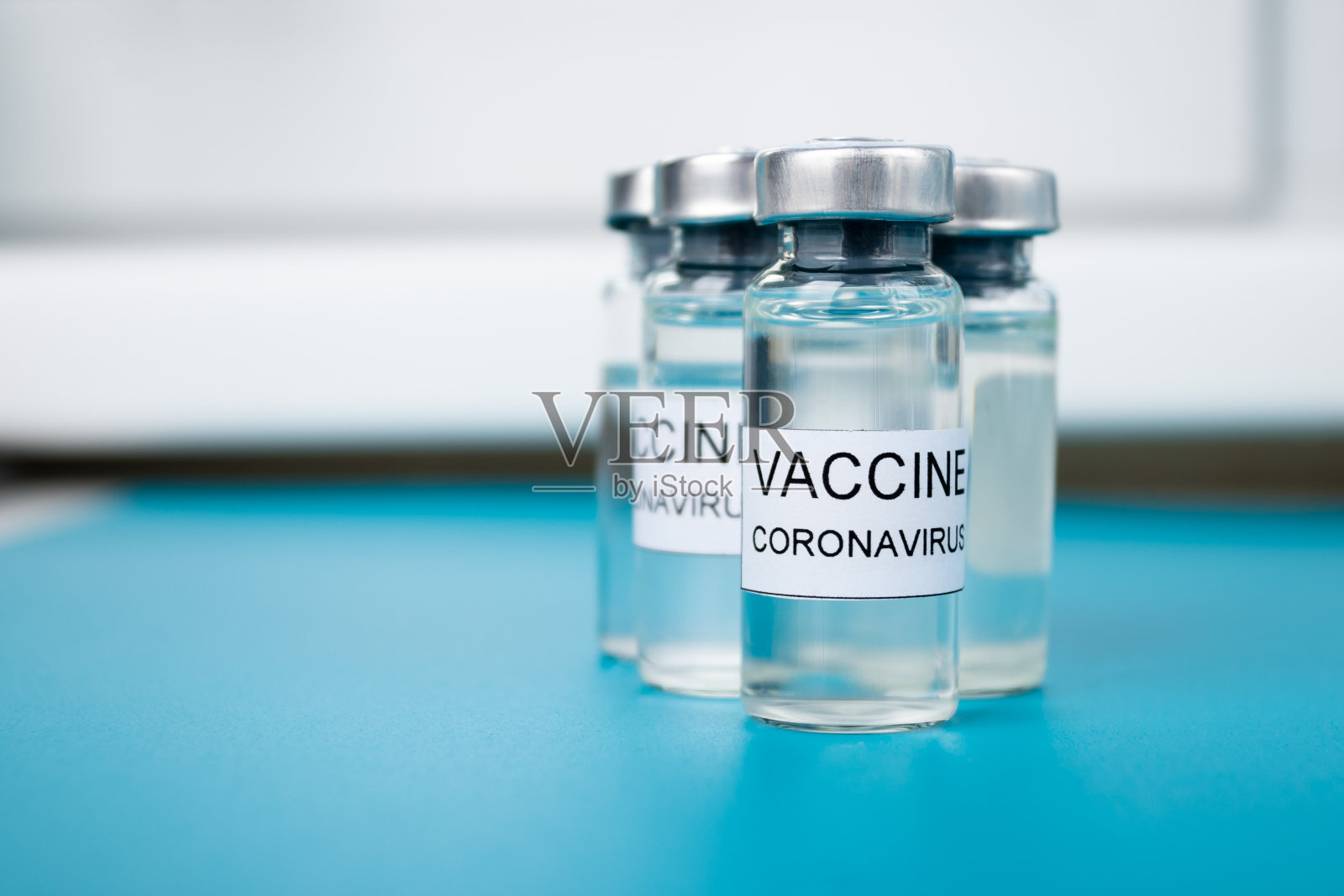 以医学蓝色为背景，接种covid-19疫苗，预防疾病照片摄影图片