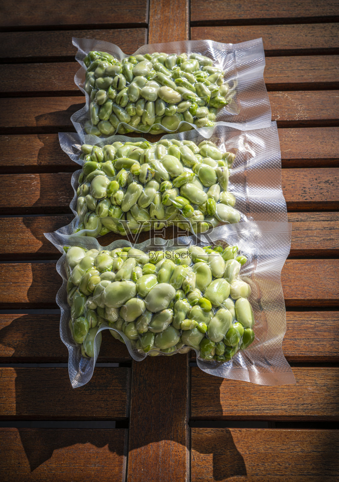 蚕豆和利马豆在真空密封塑料袋中剥皮准备冷冻照片摄影图片