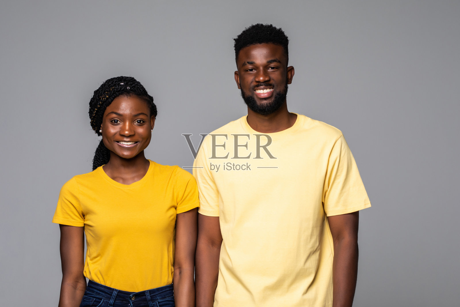 肖像微笑的非洲裔美国人站孤立在灰色的工作室背景照片摄影图片