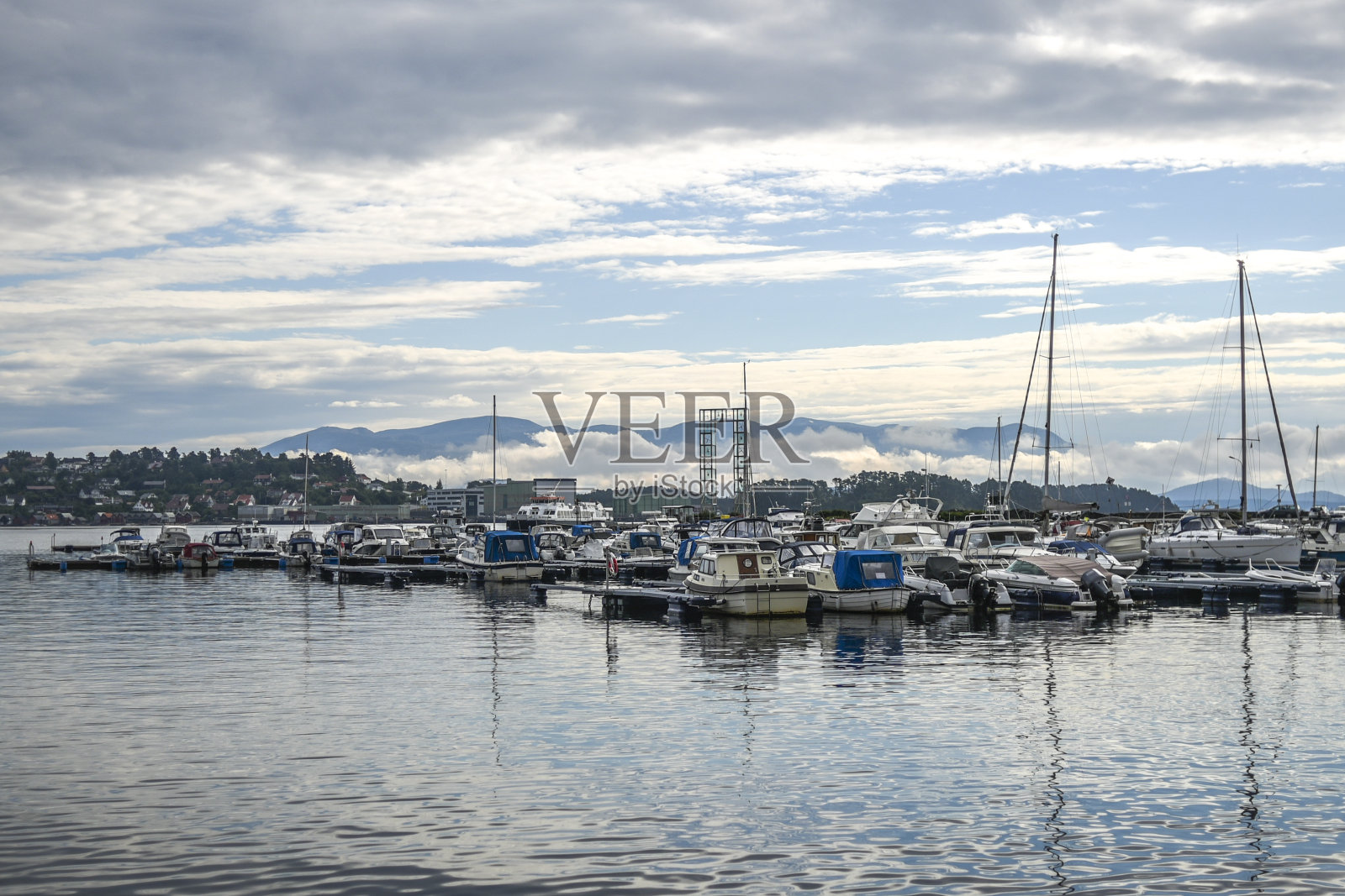 挪威Leirvik镇的码头，在峡湾上空的阴天背景中。照片摄影图片