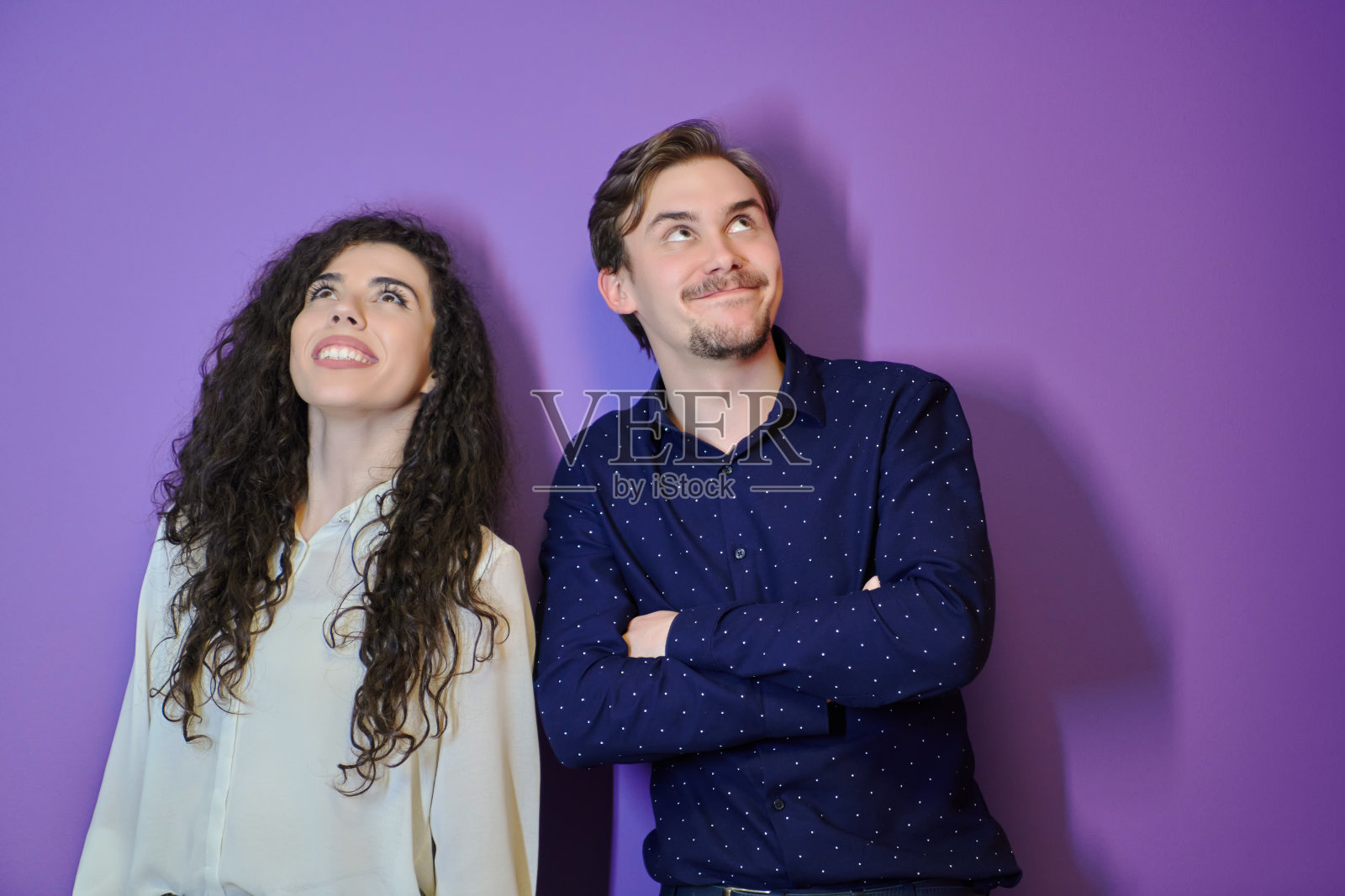 幸福的年轻夫妇在紫色的背景下摆姿势照片摄影图片