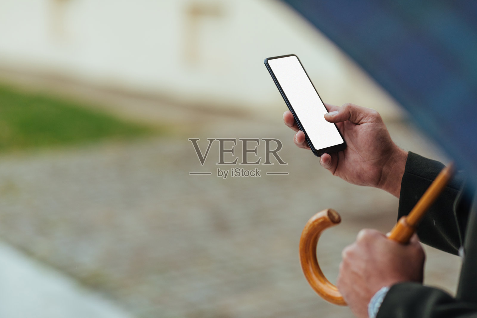 男人们撑着雨伞在街道上发短信照片摄影图片