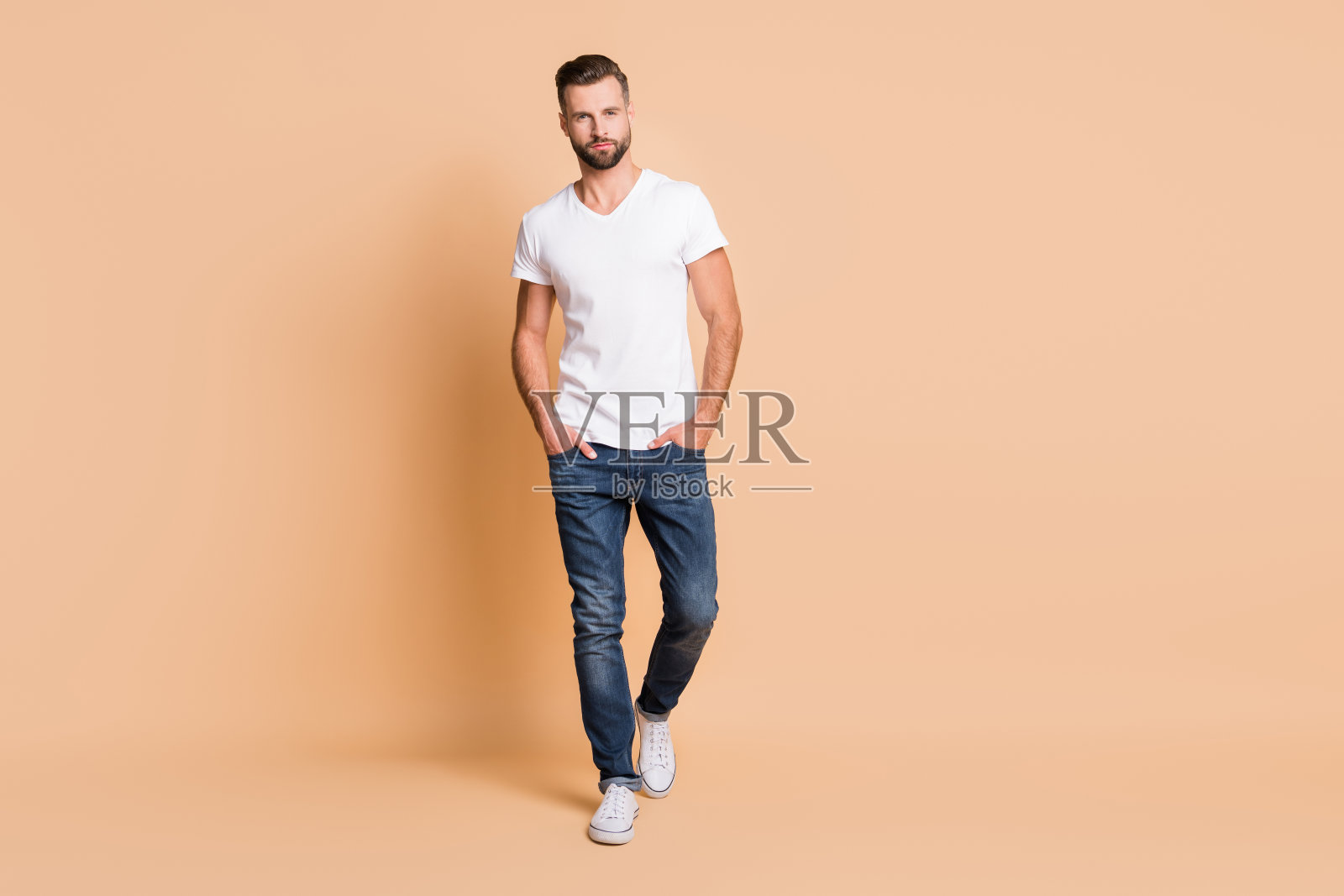 完整的长度身体尺寸的观点，好看的内容，有吸引力的高大男子气概的家伙孤立在米色柔和的颜色背景照片摄影图片