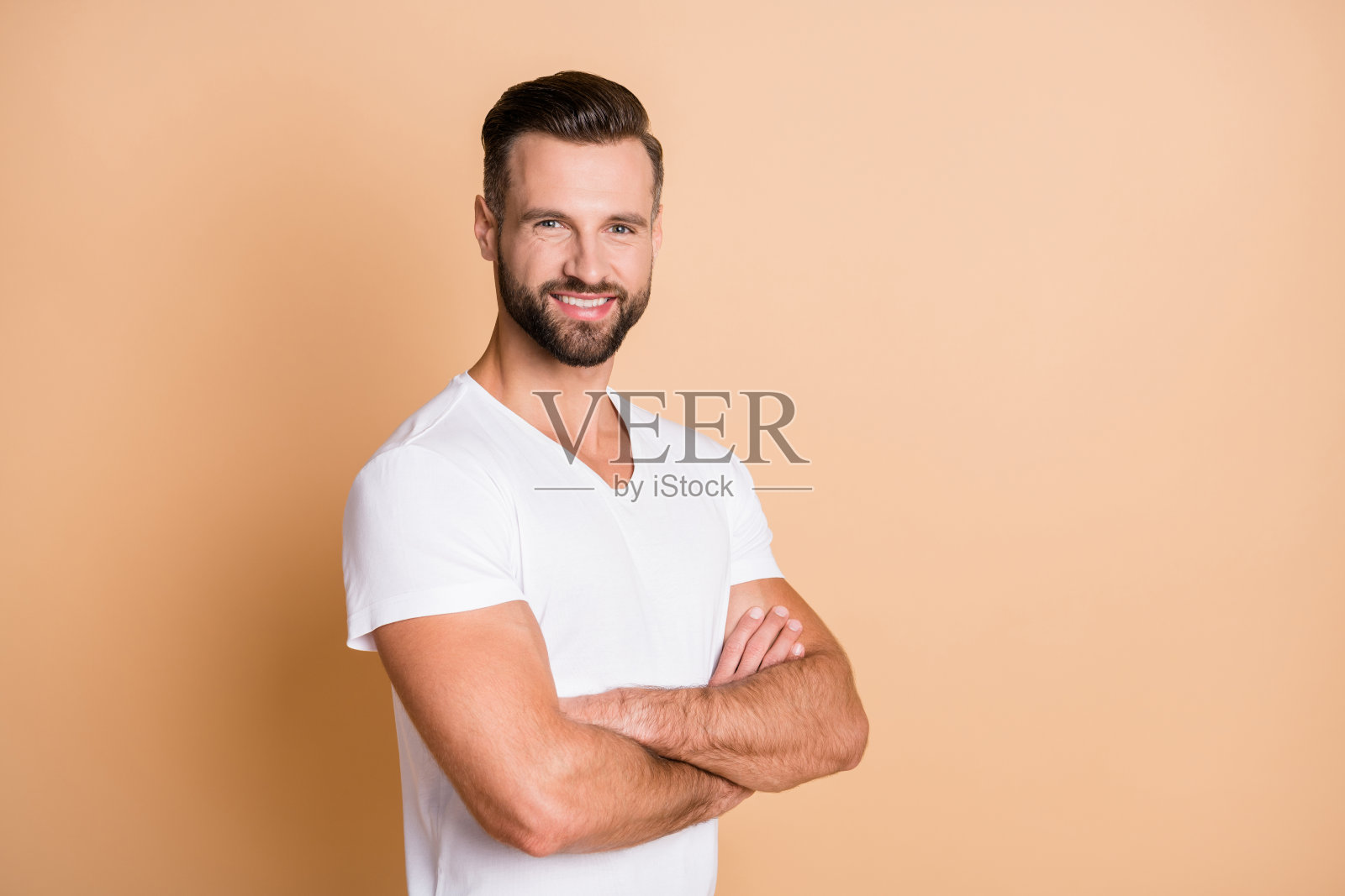 照片上的年轻英俊的商人快乐，积极的微笑，自信的双手孤立在米色背景照片摄影图片