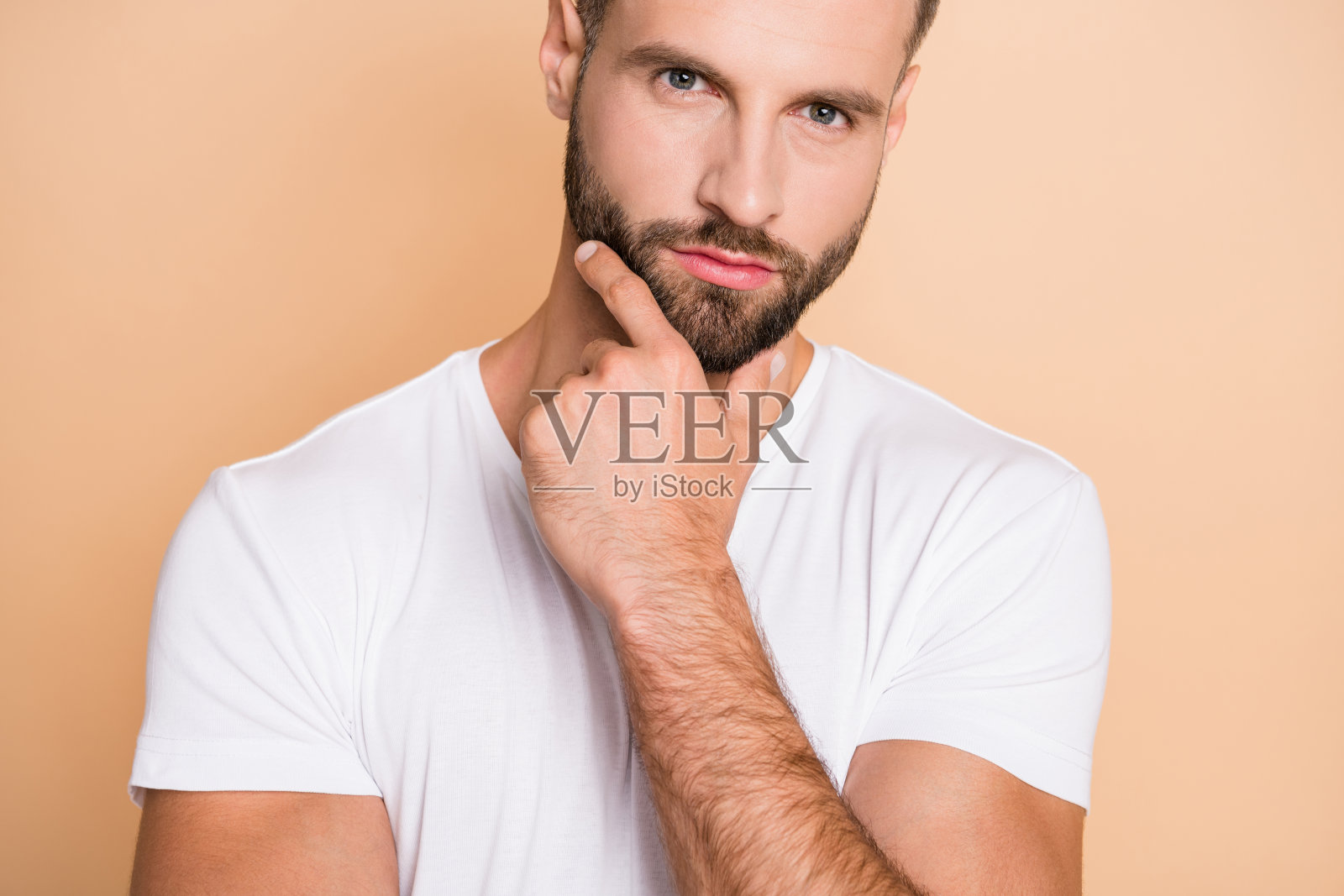 裁剪照片的年轻英俊的男人认真思考头脑风暴手触摸下巴孤立的米色背景照片摄影图片