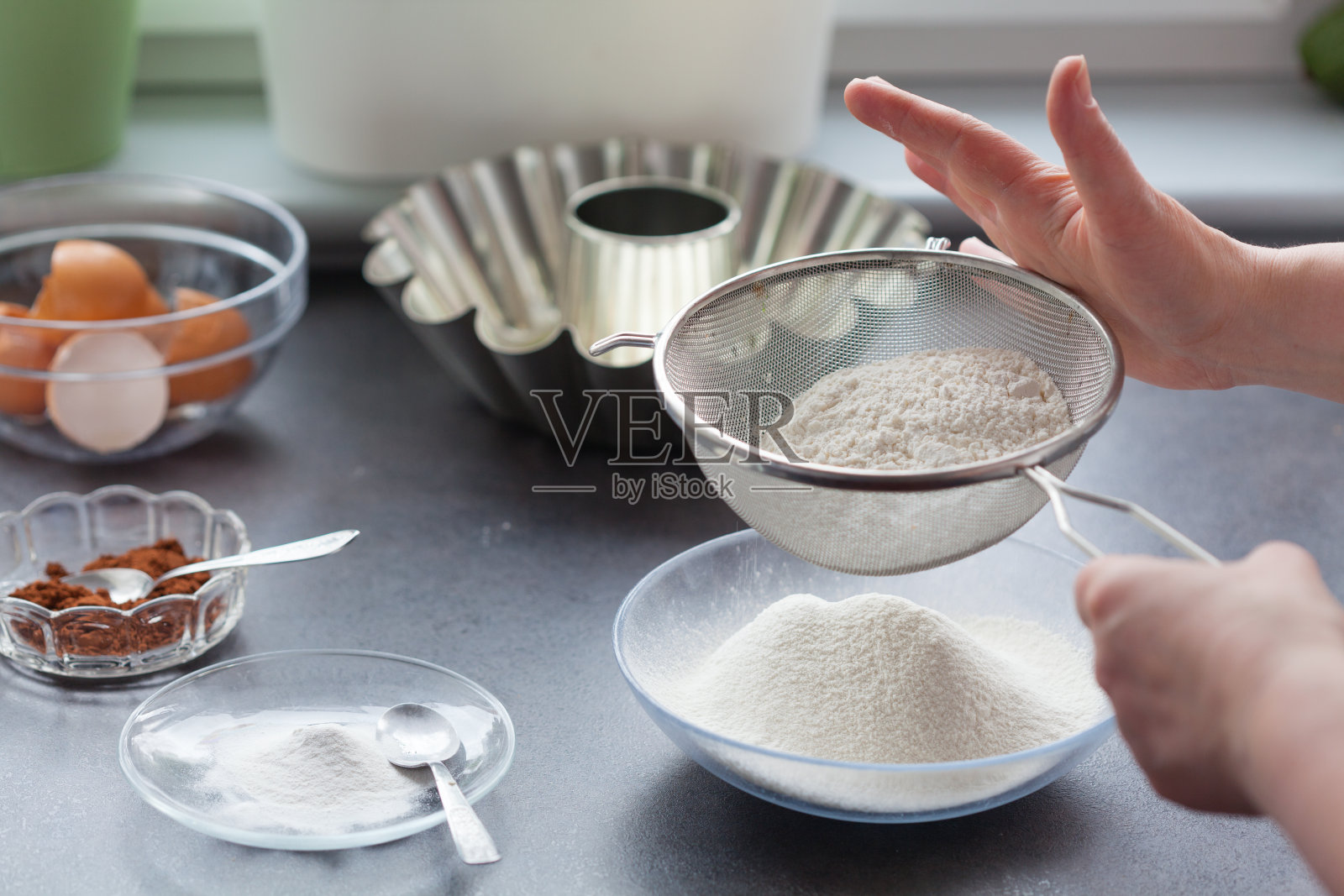 烤蛋糕。接下来的阶段，接下来的阶段。我们筛面粉。照片摄影图片