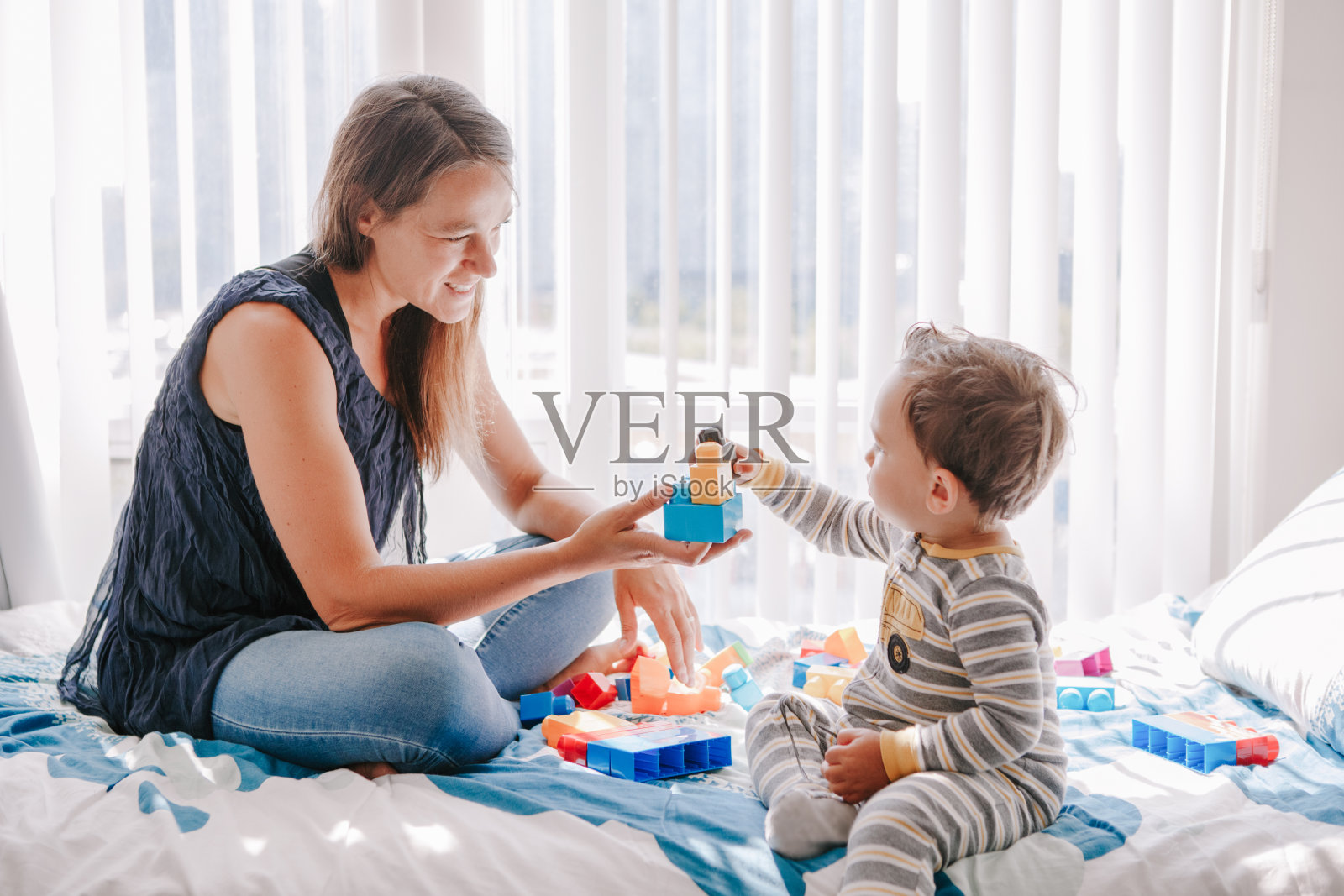 母亲和幼儿在家玩积木。早教，儿童手脑和精细运动技能发展，学龄前儿童的逻辑活动照片摄影图片