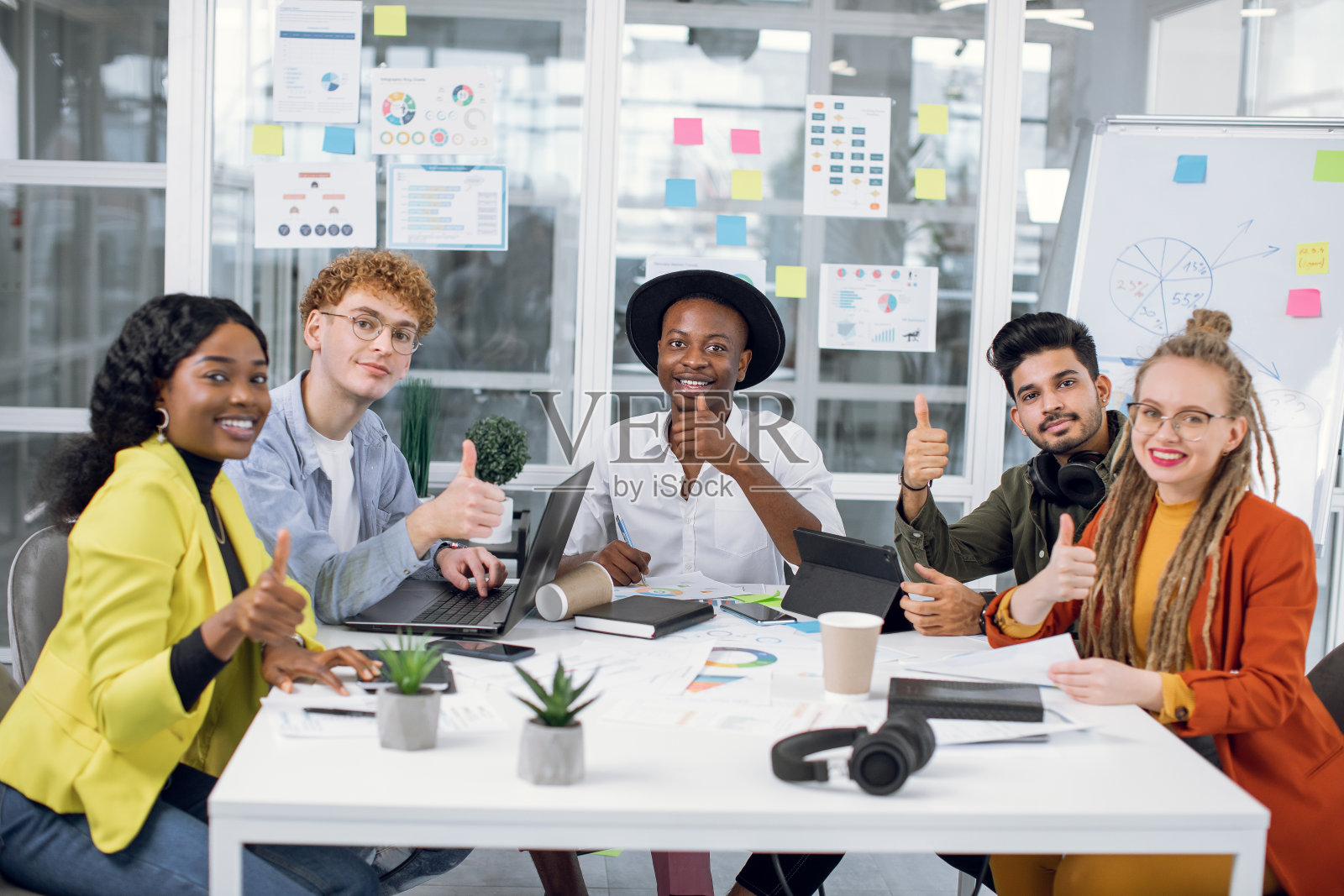 在办公室微笑着竖起大拇指的自由职业者照片摄影图片