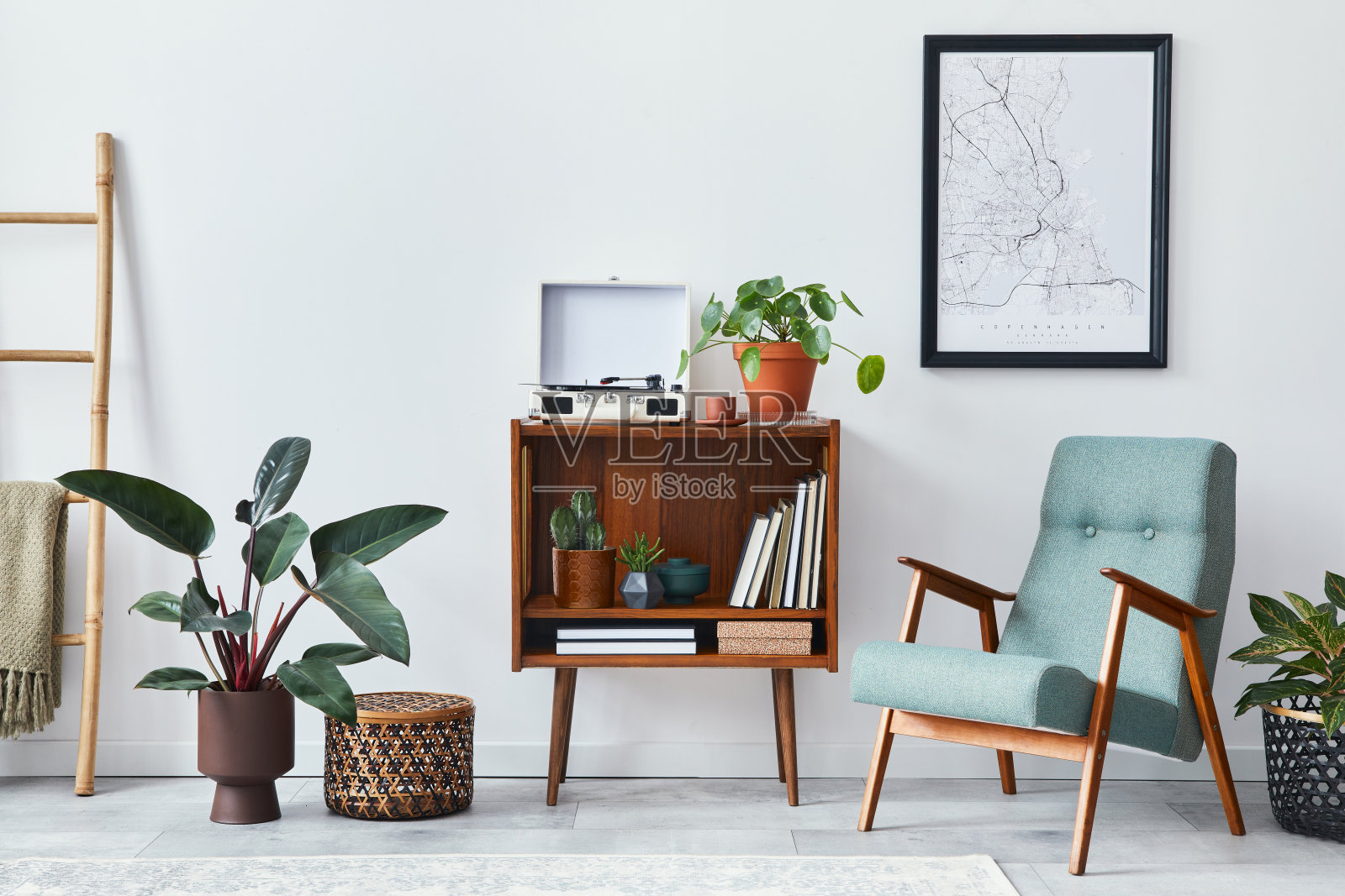 现代复古构成的客厅室内设计木质橱柜，时尚的扶手椅，模拟海报地图，植物，唱片机，书籍和个人配件在家庭装饰。模板。照片摄影图片