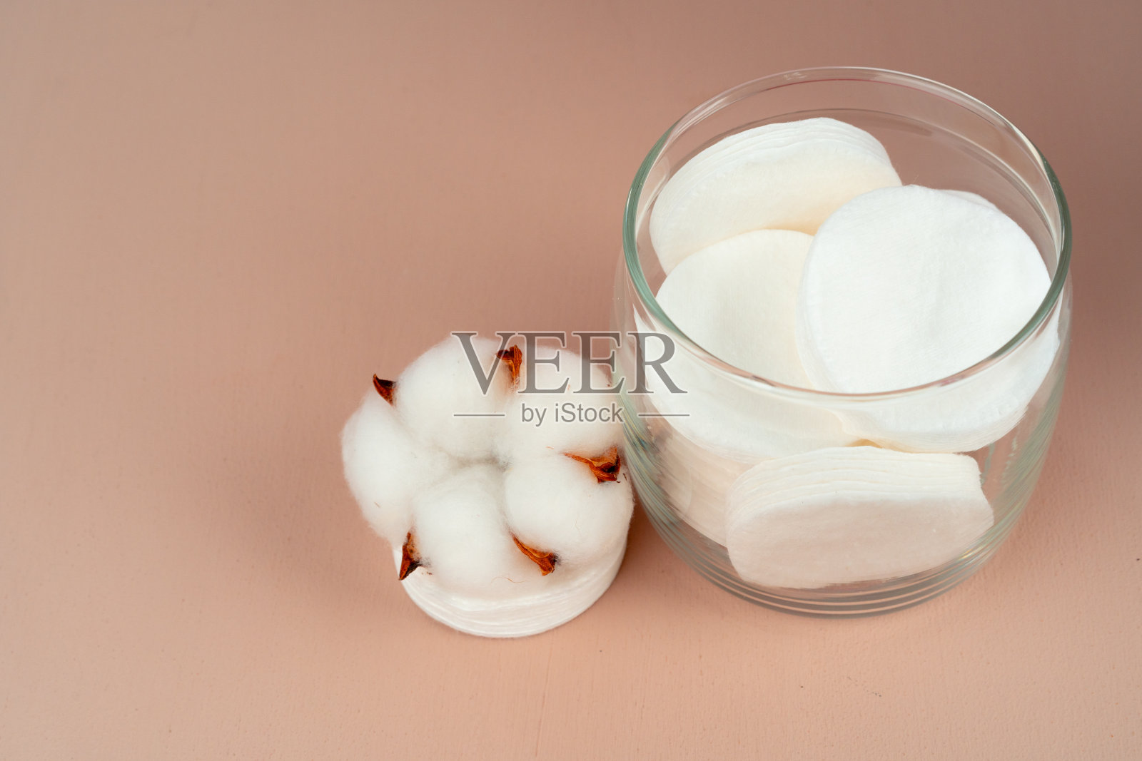 在纸背景上的一个罐子里的护肤棉圆盘照片摄影图片