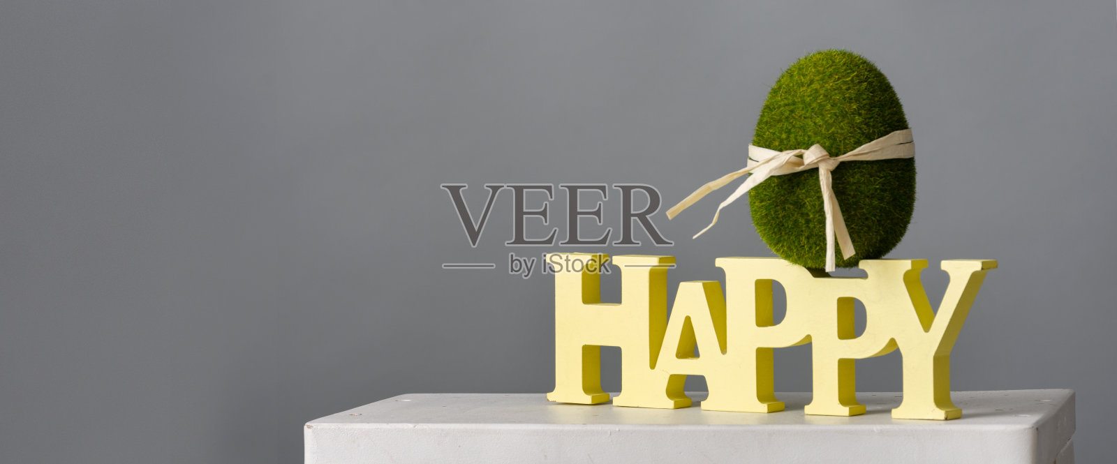 复活节作文用绿色彩蛋和木制题字，在灰色背景上，放置文字照片摄影图片