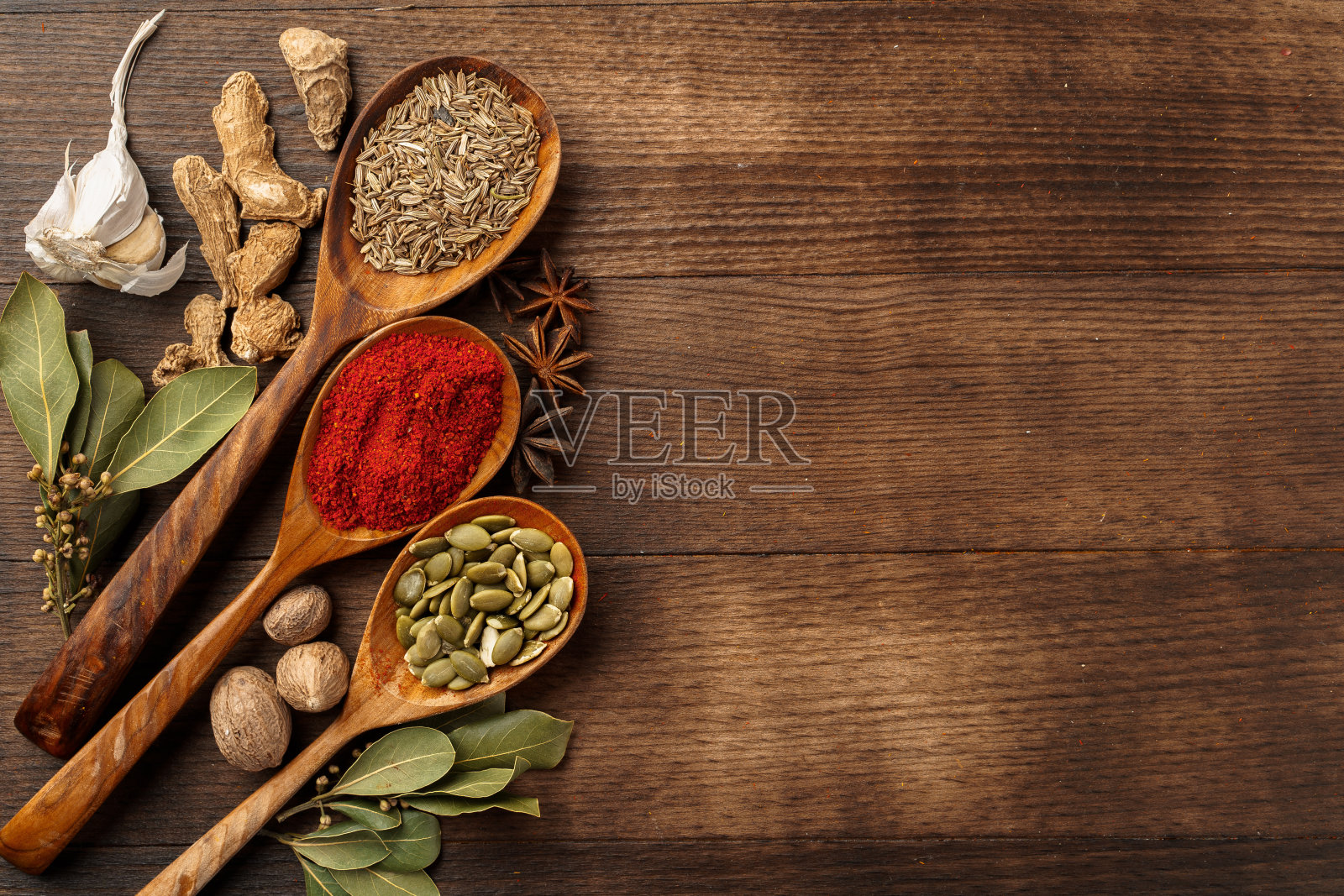 色彩鲜艳的香料在木勺上木制的背景照片摄影图片