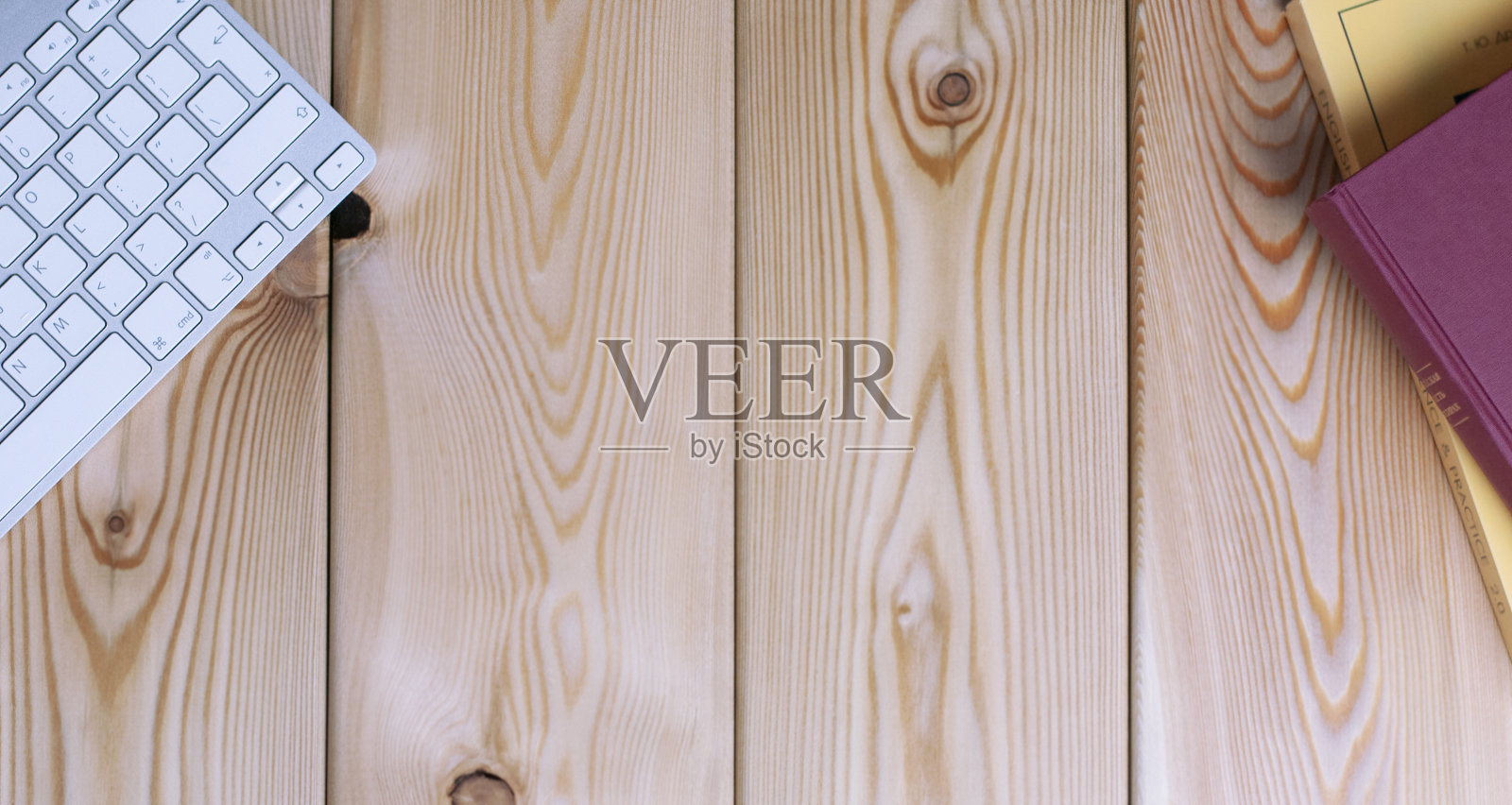 工作场所的木桌上有键盘和书照片摄影图片