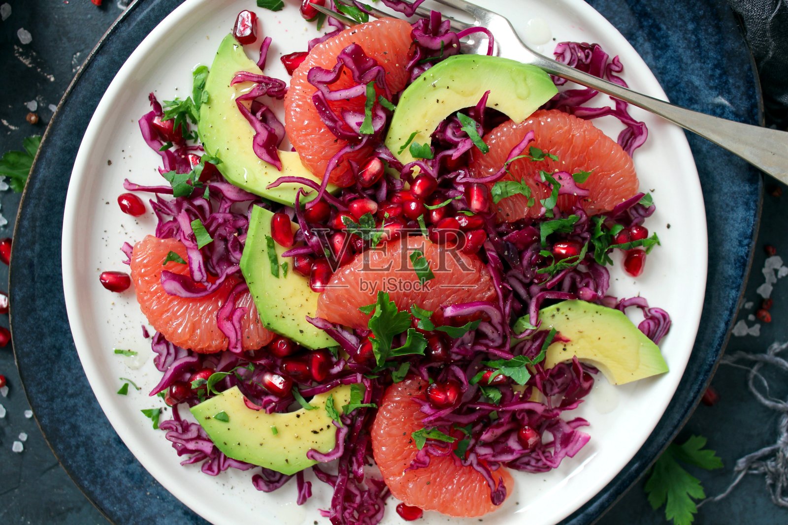 红卷心菜色拉配鳄梨，柚子和石榴。照片摄影图片