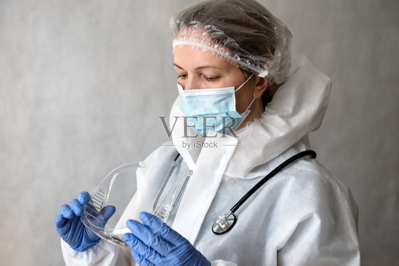 佩戴个人防护装备(PPE)的女医生，防止COVID-19冠状病毒感染照片摄影图片