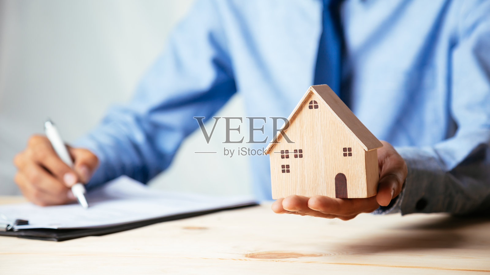 房屋模型与房地产代理和客户讨论合同买房，保险或贷款房地产，房地产概念。照片摄影图片