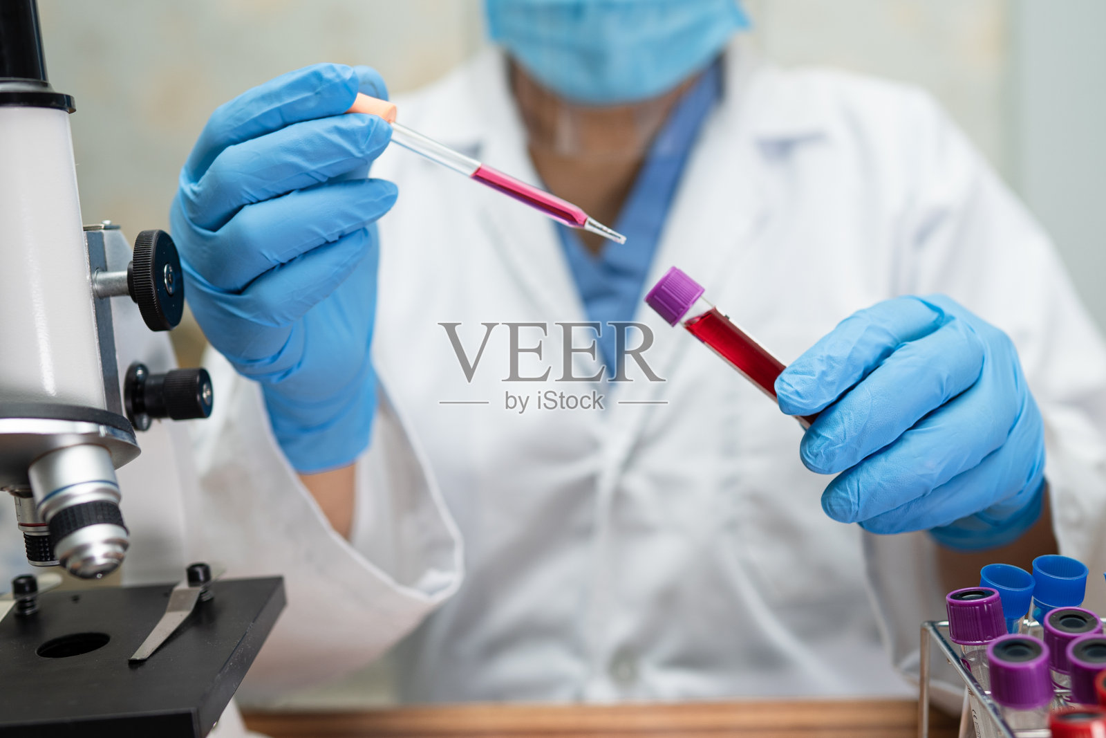 亚洲生物化学家或微生物学家，在实验室用显微镜进行研究。用于保护暴发的冠状病毒covid - 19、细菌和细菌。照片摄影图片