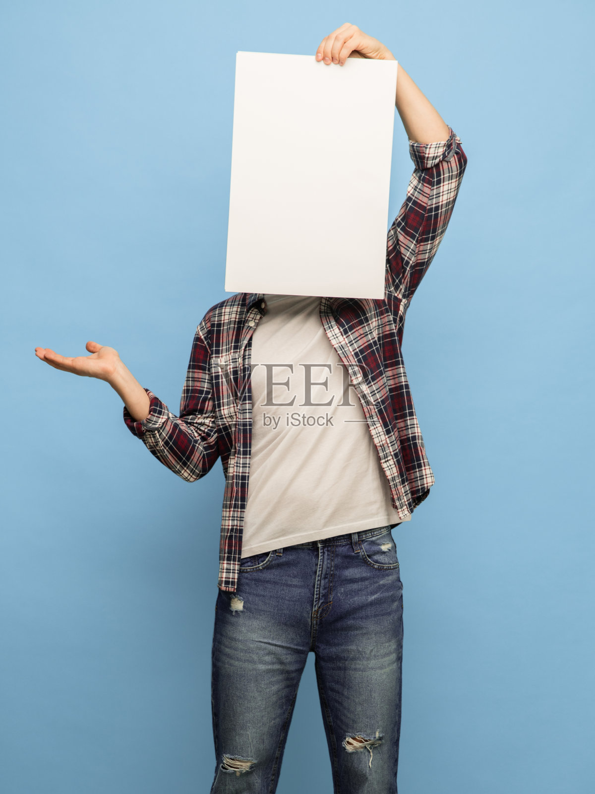 年轻人与空白纸关闭他的脸孤立在蓝色背景照片摄影图片