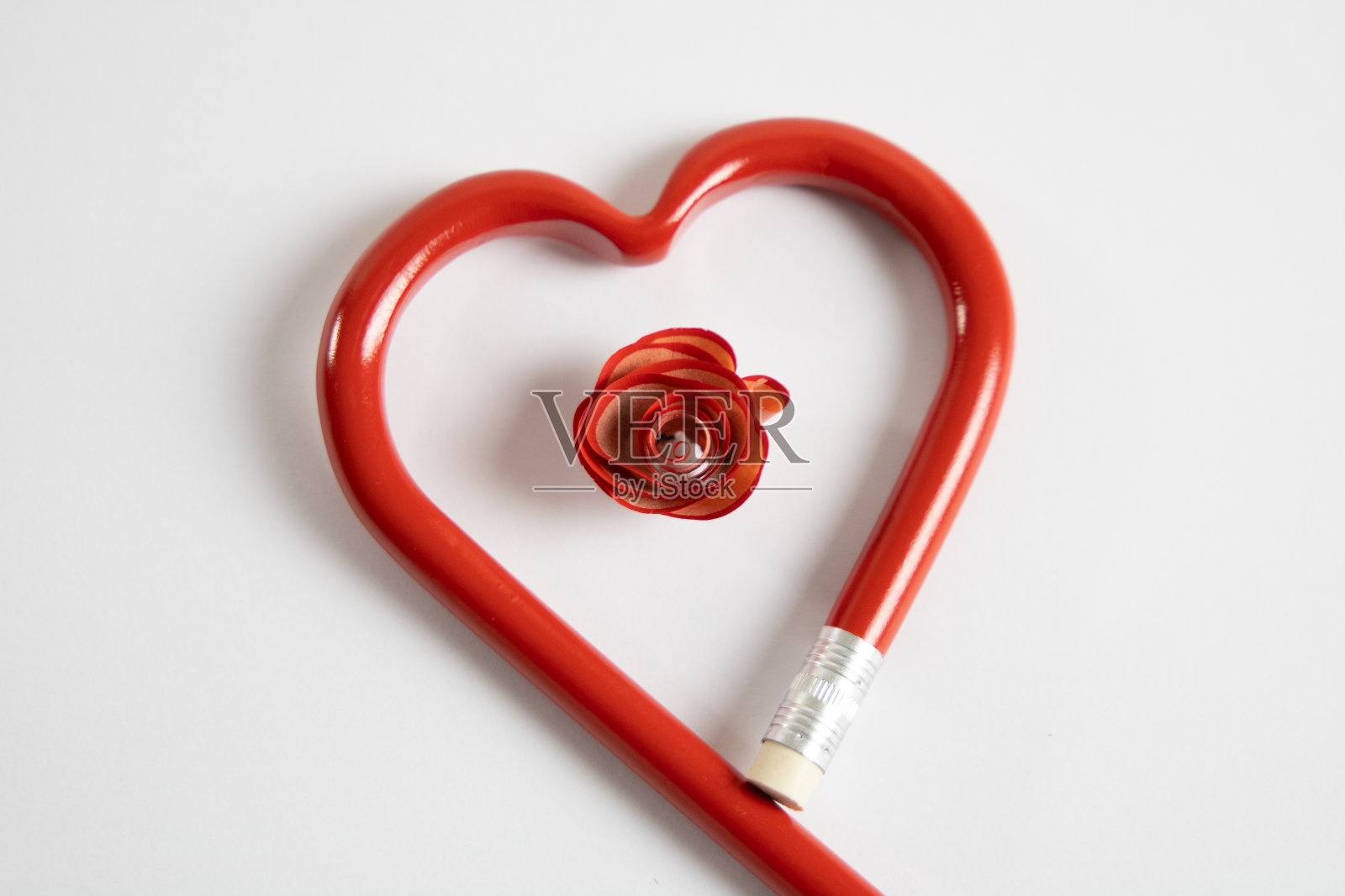 红花里面有一颗心。铅笔在一个心格式和铅笔刨花在一个格式在里面照片摄影图片