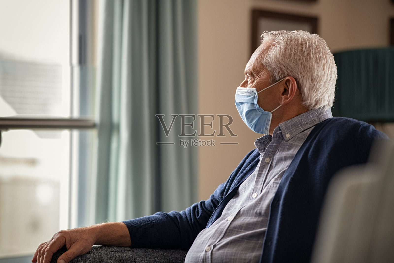 戴着口罩沉思的悲伤老年男人照片摄影图片