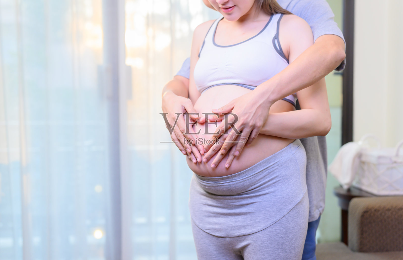 情侣们用手画出心形。怀孕的家庭生活方式。照片摄影图片