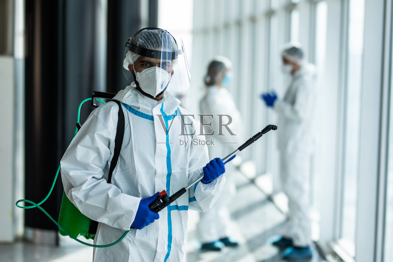 身穿白色安全防护服的医生在医院区域消毒covid-19污染疫情照片摄影图片