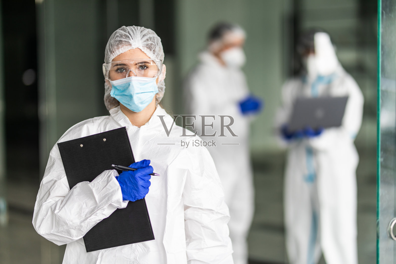 医护人员穿着防护服共同努力控制病毒的爆发照片摄影图片