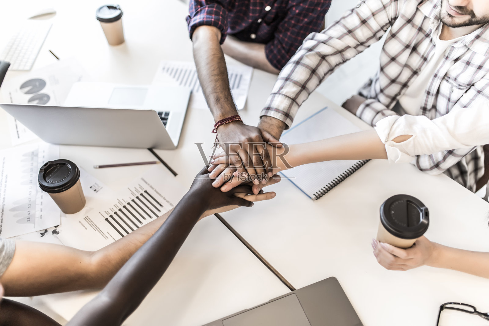 团队把手放在一起，显示联系和联盟，俯视图的工作表。办公室的团队建设，休闲的年轻男女团结起来，在新项目中进行团队合作。照片摄影图片