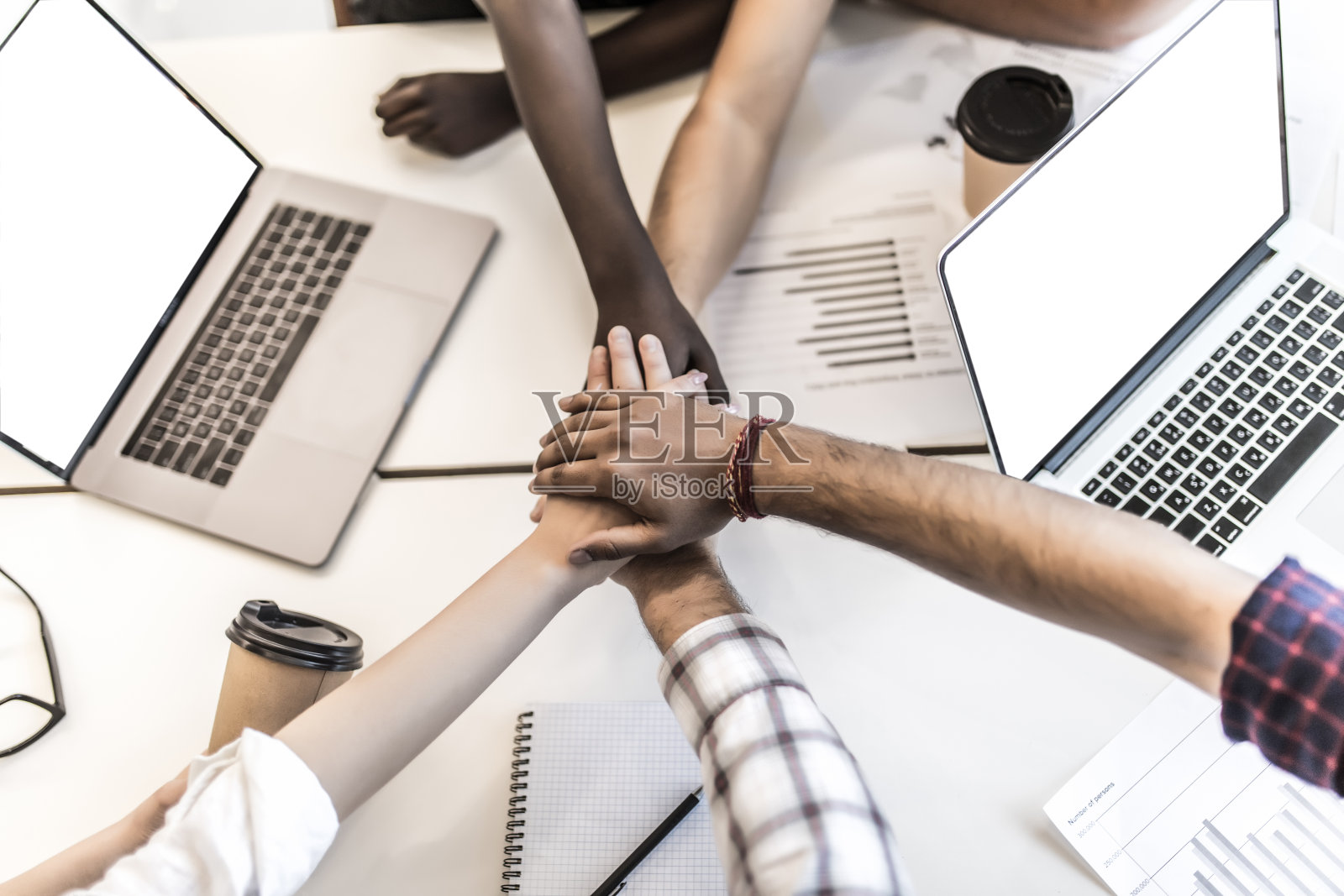 裁剪视图的商务人士把他们的手在一个漂亮的轻工作站，穿着休闲衣服。成功团队建设的概念照片摄影图片