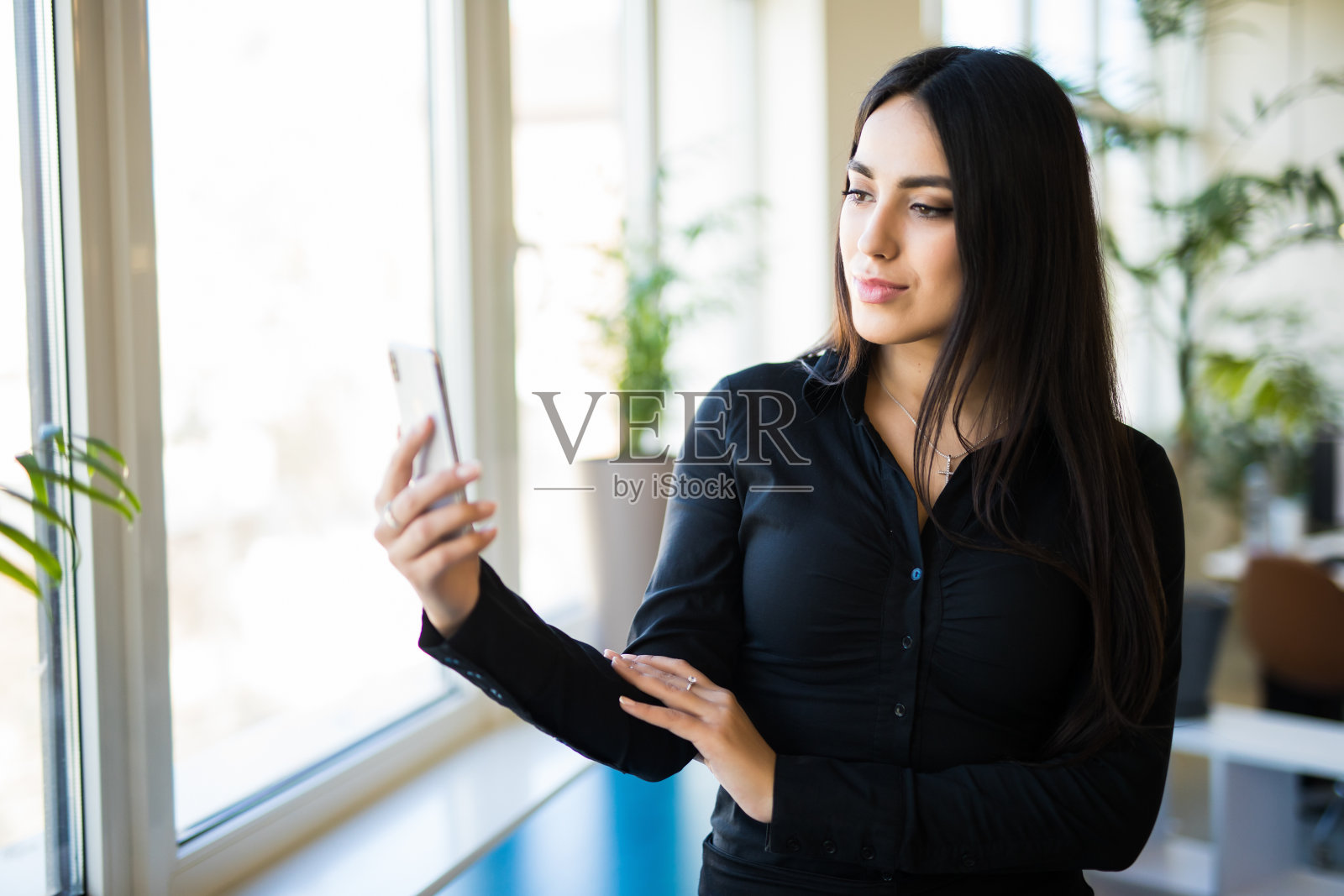 快乐的商务女性在办公桌边打字的肖像照片摄影图片