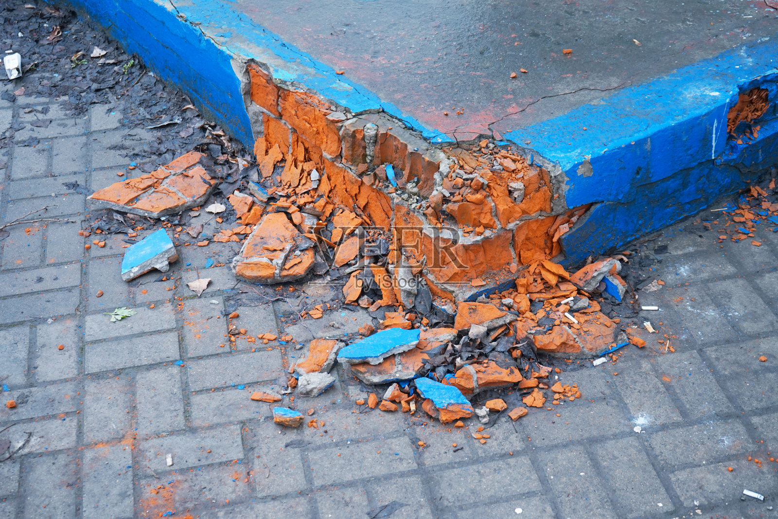 毁坏的砖墙躺在地上。破旧的砖墙，灰泥剥落。照片摄影图片