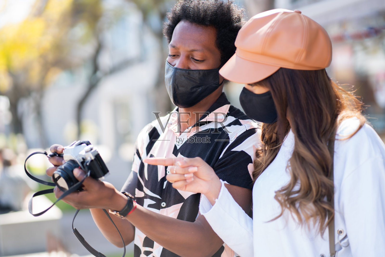 游客夫妇在户外使用相机。照片摄影图片