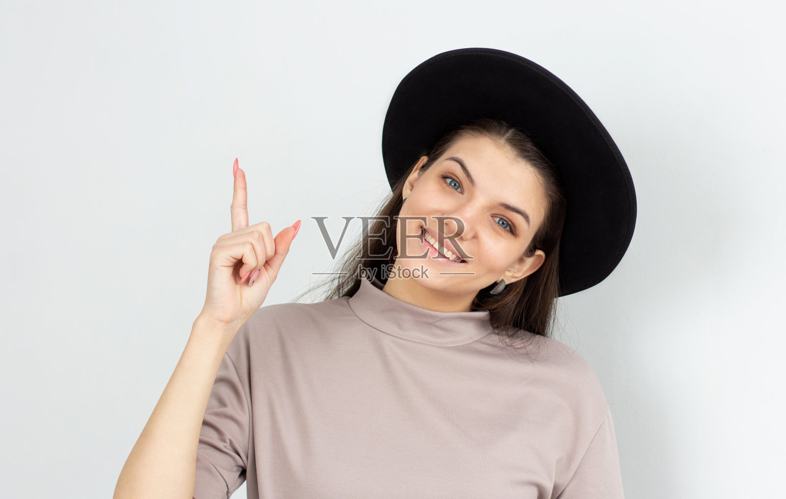一名年轻女子的肖像，指着白色的背景照片摄影图片